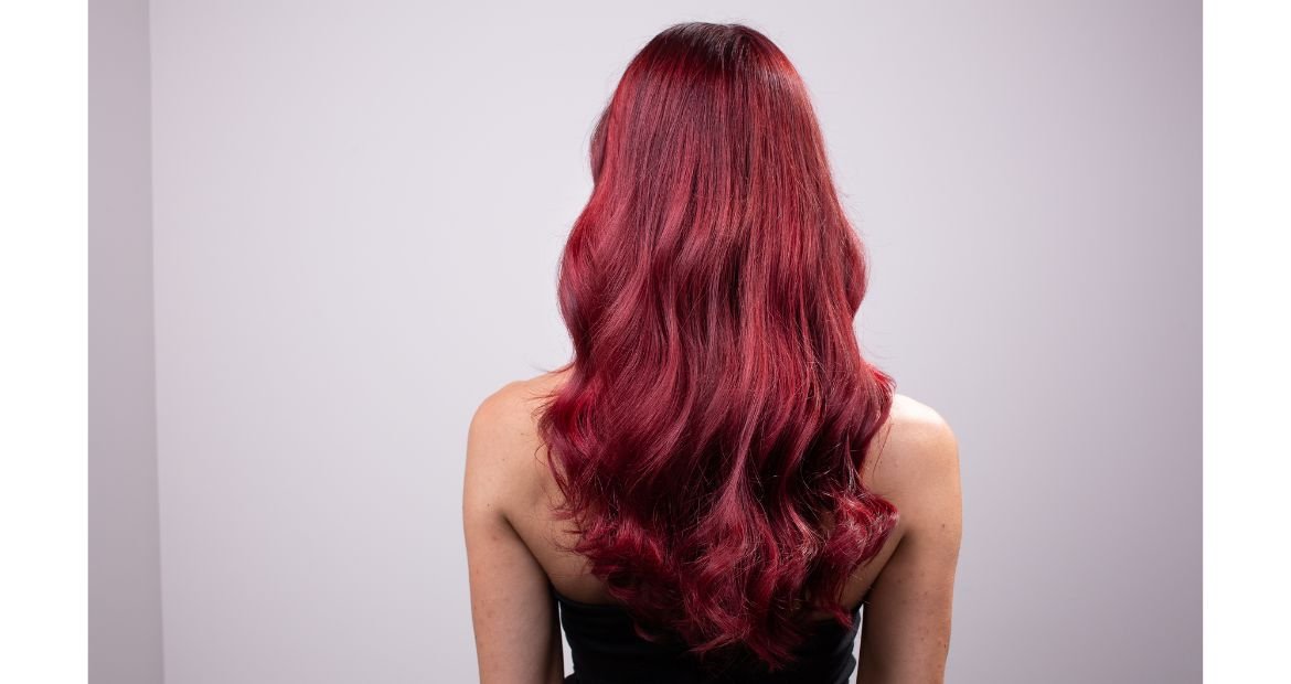 Mulher com cabelo vermelho borgonha longo.